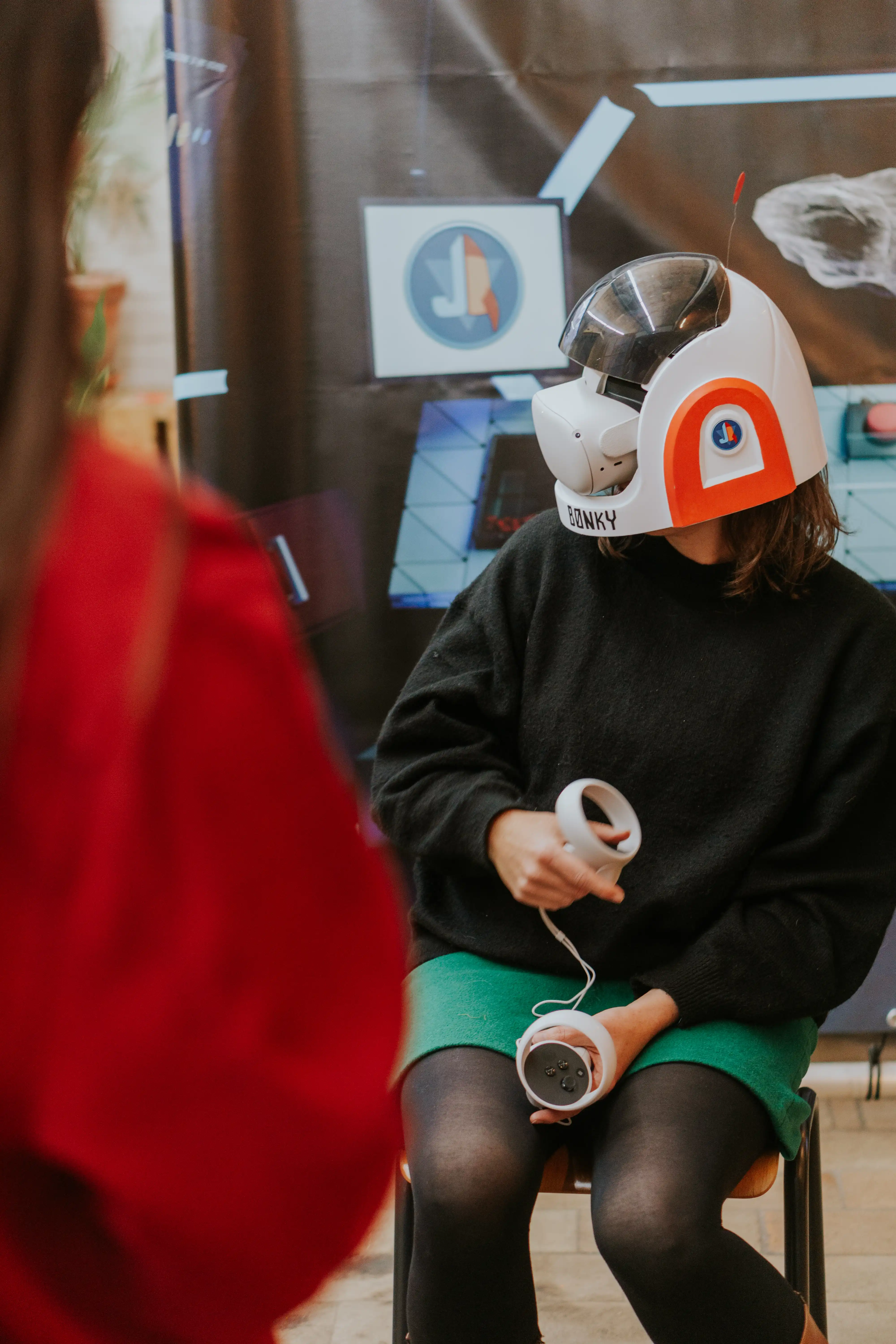 Een jonge dame test een project met een VR-bril uit, al zittend op een stoel.