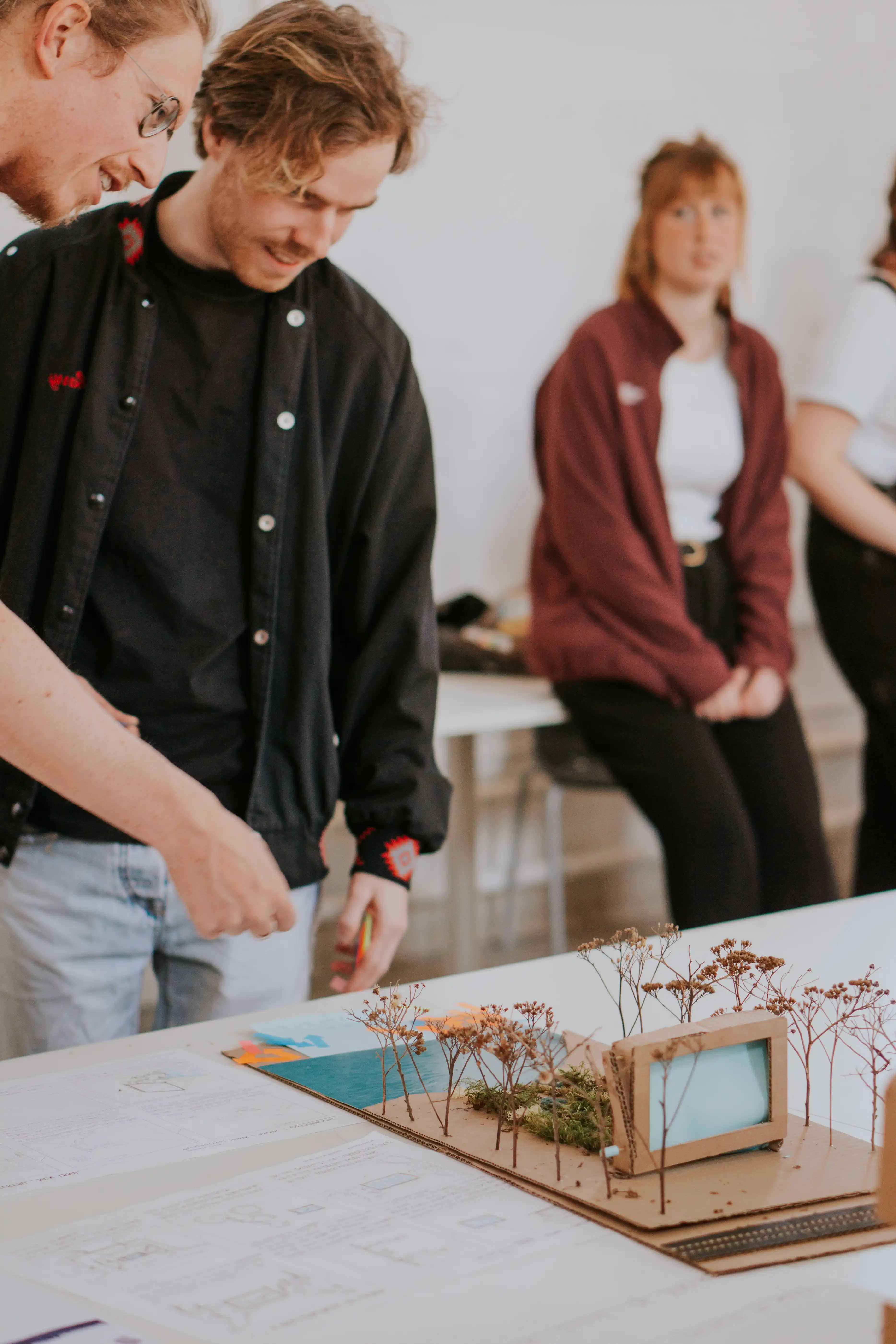 Twee personen kijken naar een maquette van een tuin.